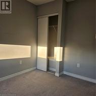 Unfurnished bedroom with carpet flooring and a closet - 