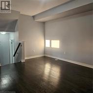 Unfurnished living room featuring dark hardwood / wood-style flooring and lofted ceiling - 