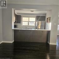 Kitchen with dark hardwood / wood-style flooring, kitchen peninsula, a breakfast bar area, and fridge - 