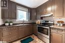 Kitchen featuring electric range, backsplash, dark stone countertops, and sink - 90 East 11Th Street, Hamilton, ON  - Indoor Photo Showing Kitchen With Double Sink 