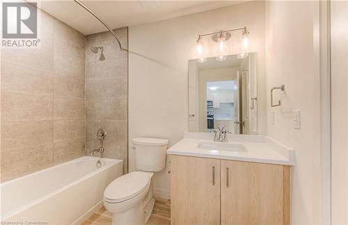 Full bathroom with hardwood / wood-style flooring, vanity, tiled shower / bath combo, and toilet - 301 Westmount Road W Unit# 204, Kitchener, ON - Indoor Photo Showing Bathroom