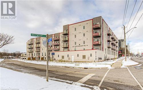 View of snow covered property - 301 Westmount Road W Unit# 204, Kitchener, ON - Outdoor With Balcony With Facade