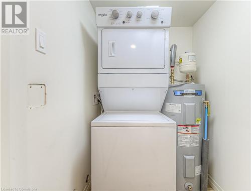 Laundry area with water heater and stacked washer and clothes dryer - 301 Westmount Road W Unit# G1, Kitchener, ON - Indoor Photo Showing Laundry Room