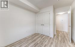 Unfurnished bedroom featuring electric panel, a closet, and light hardwood / wood-style floors - 