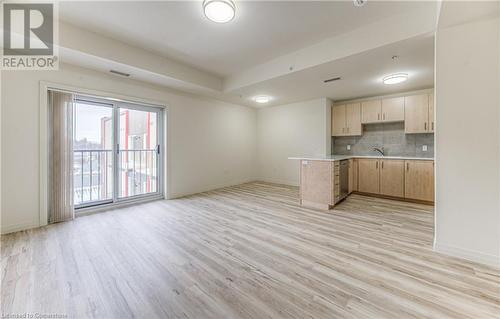 Kitchen featuring tasteful backsplash, kitchen peninsula, light brown cabinetry, and light hardwood / wood-style flooring - 301 Westmount Road W Unit# 414, Kitchener, ON - Indoor