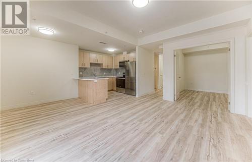 Kitchen with light brown cabinets, light hardwood / wood-style flooring, backsplash, kitchen peninsula, and appliances with stainless steel finishes - 301 Westmount Road W Unit# 414, Kitchener, ON - Indoor Photo Showing Kitchen