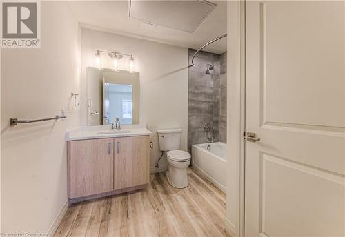 Full bathroom with hardwood / wood-style floors, vanity, tiled shower / bath combo, and toilet - 301 Westmount Road W Unit# 414, Kitchener, ON - Indoor Photo Showing Bathroom