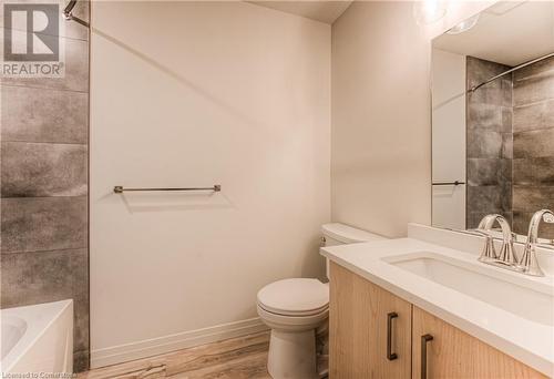 Full bathroom with hardwood / wood-style floors, vanity, toilet, and tiled shower / bath - 301 Westmount Road W Unit# 414, Kitchener, ON - Indoor Photo Showing Bathroom