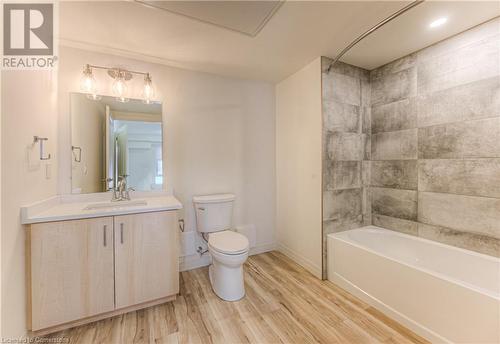 Full bathroom with toilet, wood-type flooring, vanity, and bathing tub / shower combination - 301 Westmount Road W Unit# 414, Kitchener, ON - Indoor Photo Showing Bathroom