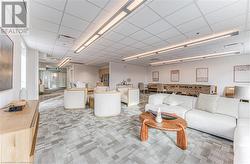 Living room with a paneled ceiling and light colored carpet - 