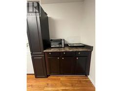 Kitchen area upstairs, complete with cabinetry, countertops, hot plate and fridge - 