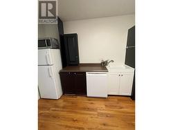 Kitchen area upstairs, complete with cabinetry, countertops, hot plate and fridge - 