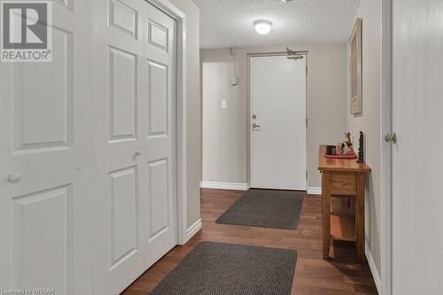 Foyer entrance featuring a textured ceiling and dark hardwood / wood-style floors - 163 Ferguson Drive Unit# 302, Woodstock, ON - Indoor Photo Showing Other Room