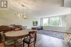 Dining area featuring hardwood / wood-style floors, a textured ceiling, and an inviting chandelier - 