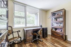 Office area with wood-type flooring and a textured ceiling - 