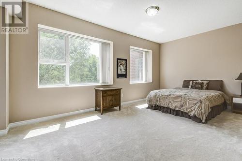 Carpeted bedroom with multiple windows - 77 Governors Road Unit# 501, Dundas, ON - Indoor Photo Showing Bedroom