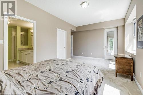 Bedroom featuring light carpet and ensuite bathroom - 77 Governors Road Unit# 501, Dundas, ON - Indoor Photo Showing Bedroom