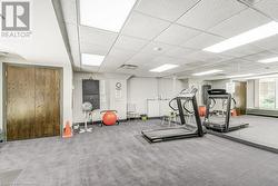 Workout area with a paneled ceiling and carpet floors - 