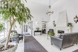 Living room featuring a fireplace, a towering ceiling, and a notable chandelier - 