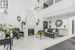 Living room featuring a high end fireplace, a notable chandelier, and a high ceiling - 