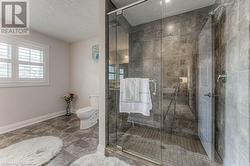 Bathroom with a textured ceiling, an enclosed shower, and toilet - 