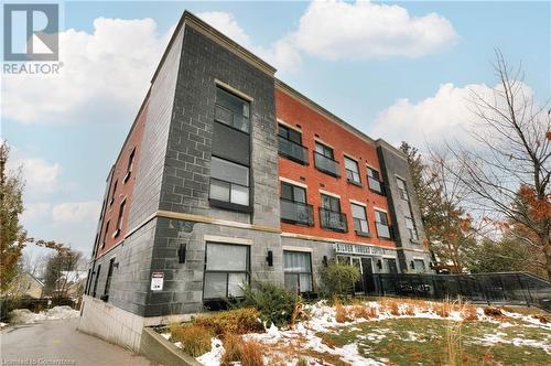 View of snow covered building - 15 Devitt Avenue S Unit# 103, Waterloo, ON - Outdoor With Facade