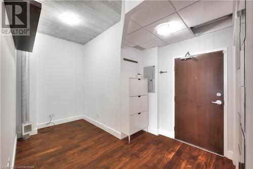 Foyer entrance with dark hardwood / wood-style flooring and electric panel - 15 Devitt Avenue S Unit# 103, Waterloo, ON - Indoor Photo Showing Other Room