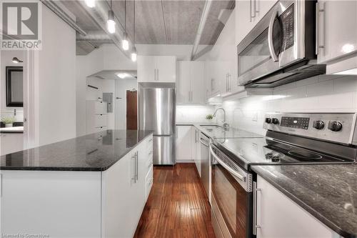 Kitchen featuring white cabinets, sink, dark hardwood / wood-style floors, appliances with stainless steel finishes, and a kitchen island - 15 Devitt Avenue S Unit# 103, Waterloo, ON - Indoor Photo Showing Kitchen With Upgraded Kitchen