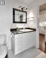 Bathroom with decorative backsplash, hardwood / wood-style floors, vanity, and toilet - 