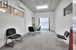 Living area with light colored carpet and a wall unit AC - 