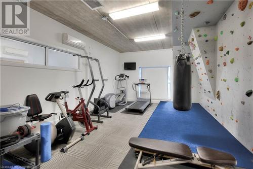 Exercise room with an AC wall unit and light colored carpet - 15 Devitt Avenue S Unit# 103, Waterloo, ON - Indoor Photo Showing Gym Room