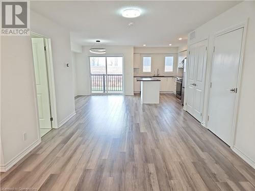 Kitchen with backsplash, sink, stainless steel electric range oven, light hardwood / wood-style floors, and white cabinetry - 235 Chapel Hill Dr Drive Unit# 16, Kitchener, ON - Indoor Photo Showing Other Room