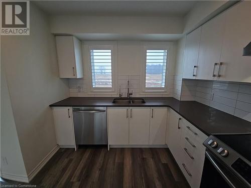 Kitchen featuring sink, stainless steel dishwasher, electric range oven, dark hardwood / wood-style flooring, and white cabinetry - 235 Chapel Hill Dr Drive Unit# 16, Kitchener, ON - Indoor Photo Showing Kitchen With Double Sink