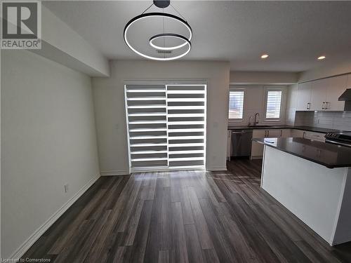 Kitchen with white cabinetry, sink, dark hardwood / wood-style flooring, stainless steel dishwasher, and pendant lighting - 235 Chapel Hill Dr Drive Unit# 16, Kitchener, ON - Indoor