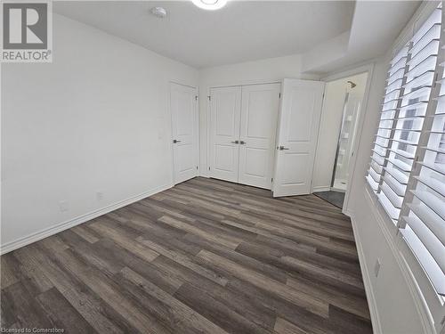 Unfurnished bedroom with dark wood-type flooring and a closet - 235 Chapel Hill Dr Drive Unit# 16, Kitchener, ON - Indoor Photo Showing Other Room