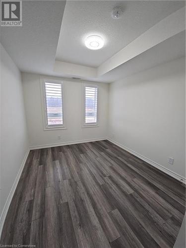 Unfurnished room featuring a textured ceiling and dark wood-type flooring - 235 Chapel Hill Dr Drive Unit# 16, Kitchener, ON - Indoor Photo Showing Other Room