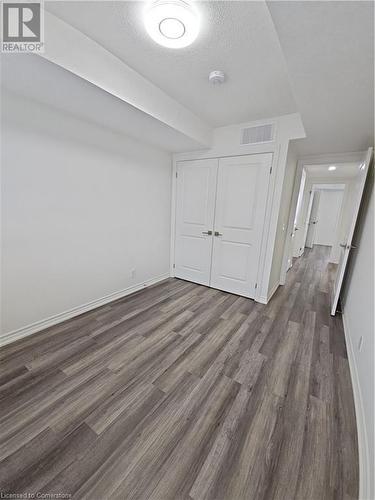 Additional living space featuring a textured ceiling and dark hardwood / wood-style floors - 235 Chapel Hill Dr Drive Unit# 16, Kitchener, ON - Indoor Photo Showing Other Room