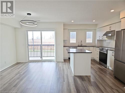 Kitchen with a wealth of natural light, stainless steel appliances, white cabinetry, and hanging light fixtures - 235 Chapel Hill Dr Drive Unit# 16, Kitchener, ON - Indoor Photo Showing Kitchen With Upgraded Kitchen