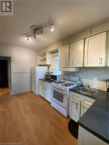 Kitchen featuring white cabinets, white range, light hardwood / wood-style flooring, and sink - 522 Roxborough Avenue Unit# #1, Hamilton, ON - Indoor Photo Showing Kitchen