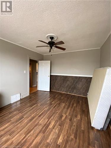 Empty room with ceiling fan, dark wood-type flooring, and a textured ceiling - 522 Roxborough Avenue Unit# #1, Hamilton, ON - Indoor Photo Showing Other Room