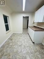 Kitchen featuring white cabinets and lofted ceiling - 