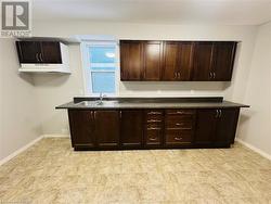 Kitchen featuring dark brown cabinetry and sink - 