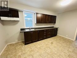 Kitchen featuring dark brown cabinetry and sink - 