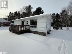 View of front of house featuring a wooden deck - 