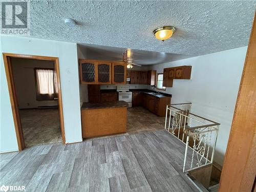 Kitchen with a textured ceiling, white range with electric stovetop, ceiling fan, sink, and hardwood / wood-style flooring - 32299 Highway 17 E, Deep River, ON - Indoor