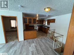 Kitchen with a textured ceiling, white range with electric stovetop, ceiling fan, sink, and hardwood / wood-style flooring - 