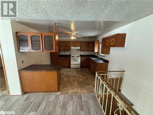 Kitchen featuring ceiling fan, sink, dark hardwood / wood-style flooring, white range with electric stovetop, and kitchen peninsula - 32299 Highway 17 E, Deep River, ON - Indoor Photo Showing Other Room