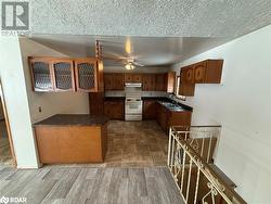 Kitchen featuring ceiling fan, sink, dark hardwood / wood-style flooring, white range with electric stovetop, and kitchen peninsula - 