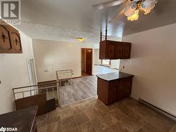 Kitchen featuring a textured ceiling, ceiling fan, and a baseboard heating unit - 