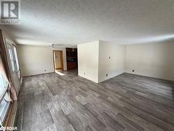 Spare room featuring ceiling fan, a textured ceiling, and hardwood / wood-style flooring - 